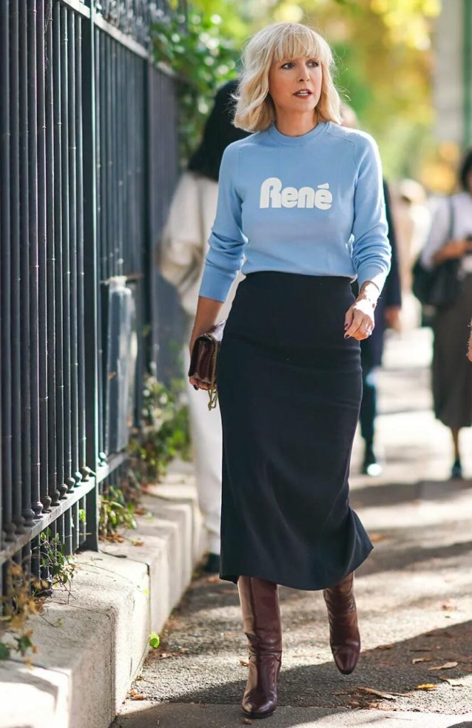 Imagen de outfit: suéter celeste, falda larga azul y color botas marrón.